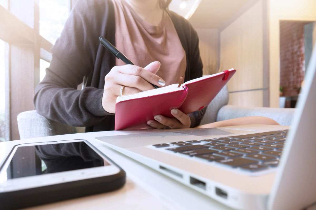 persona che scrive in un taccuino